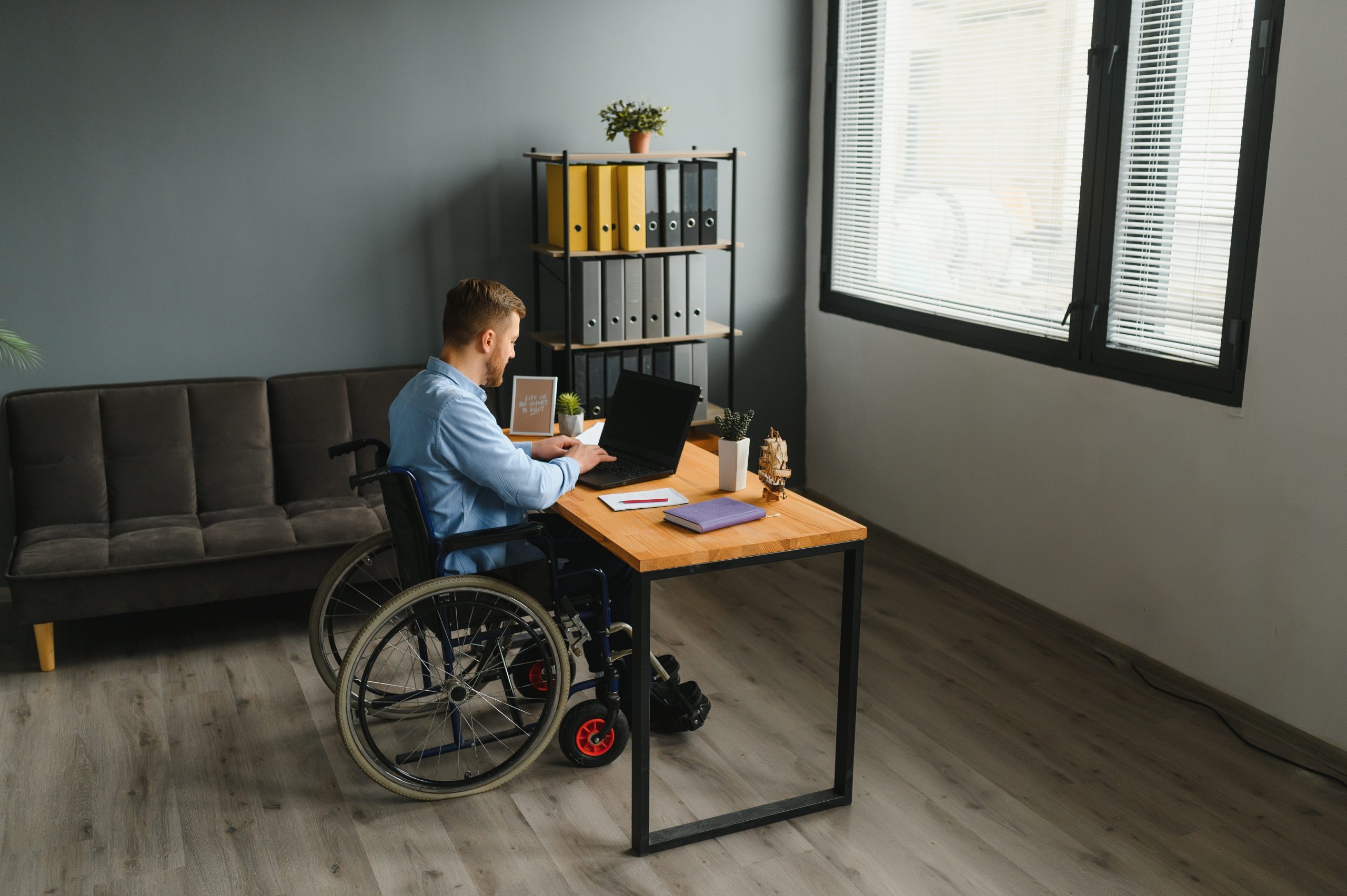 Man in wheelchair at home or in office.